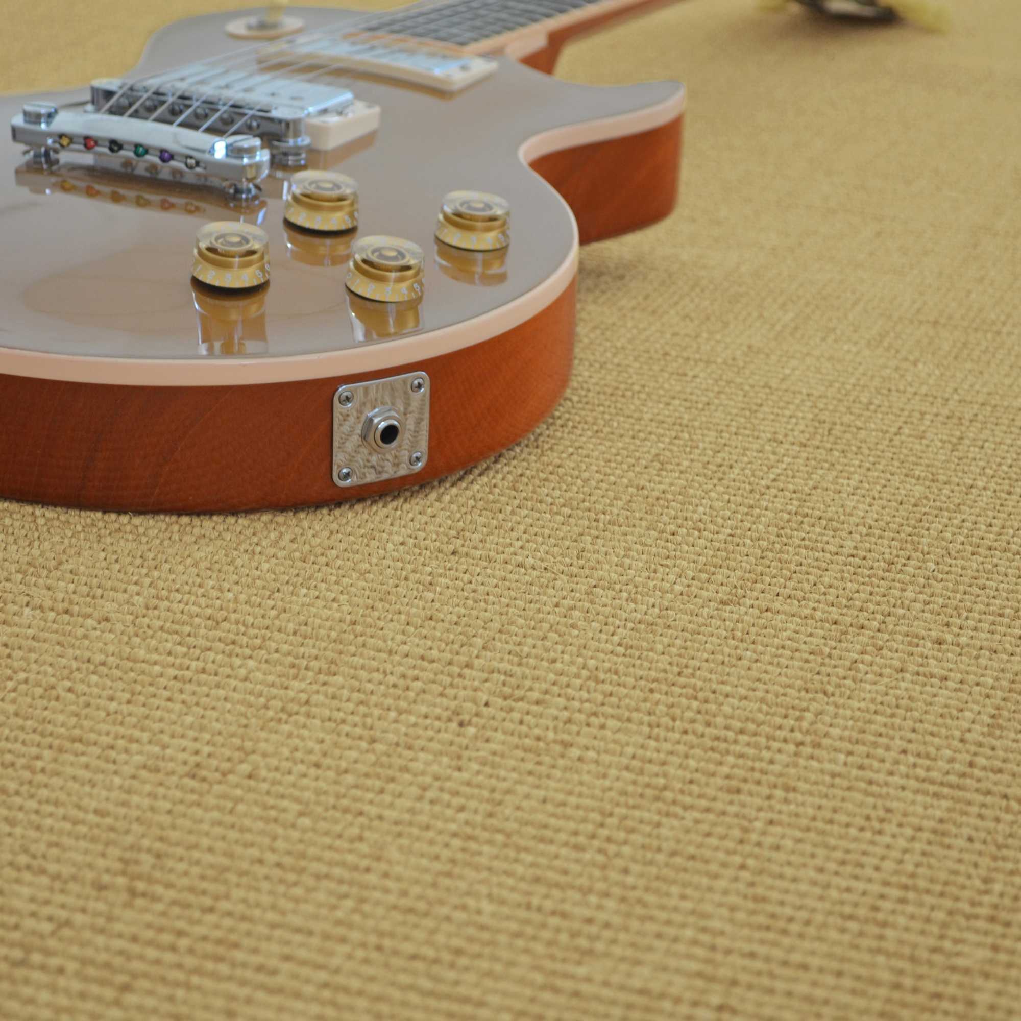 Sol Sisal - Minimal - Camel doré avec guitare électrique posée sur le revêtement en fibres naturelles
