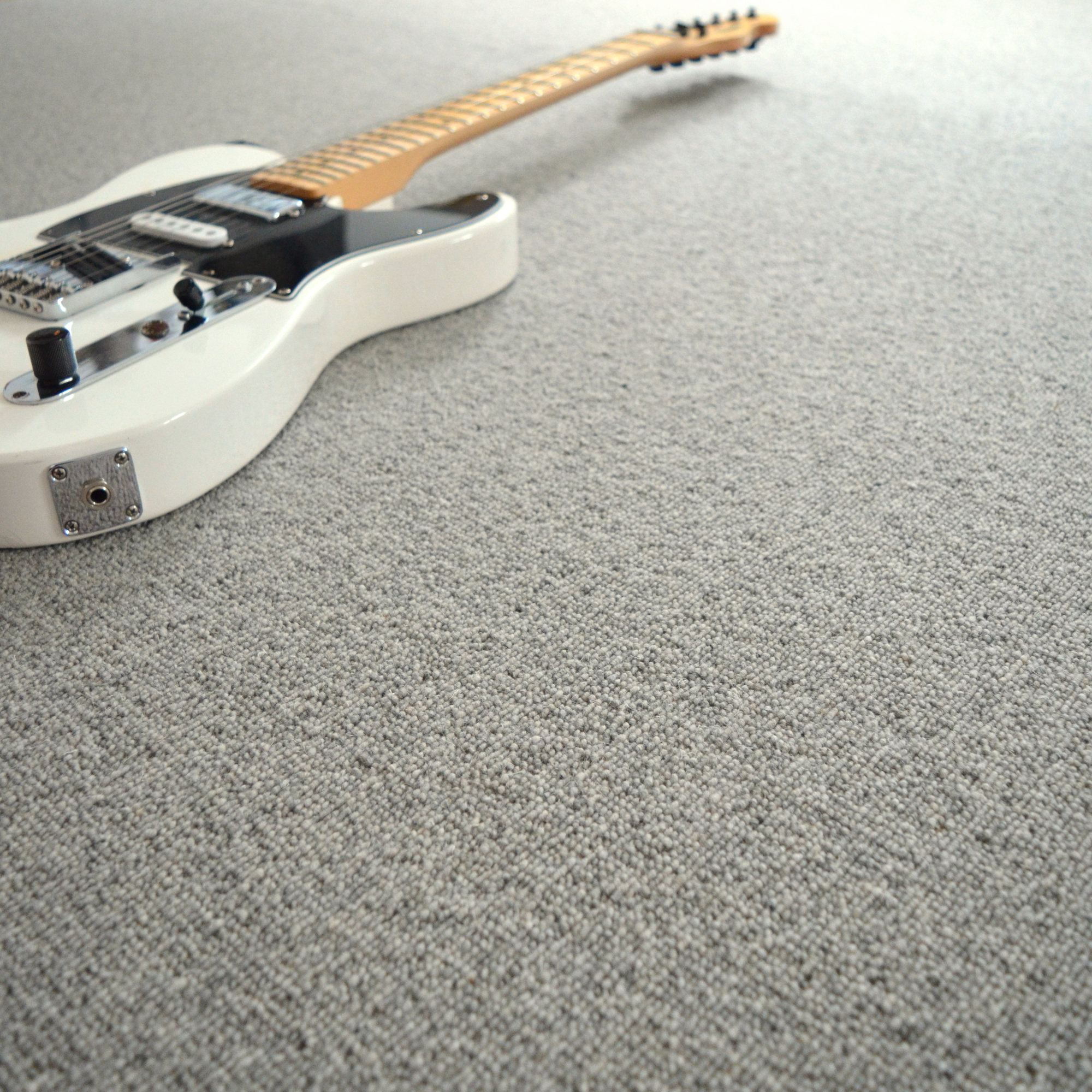 Moquette naturelle en laine - Dolce Vita - Gris nuage avec guitare électrique dans une ambiance douce et contemporaine