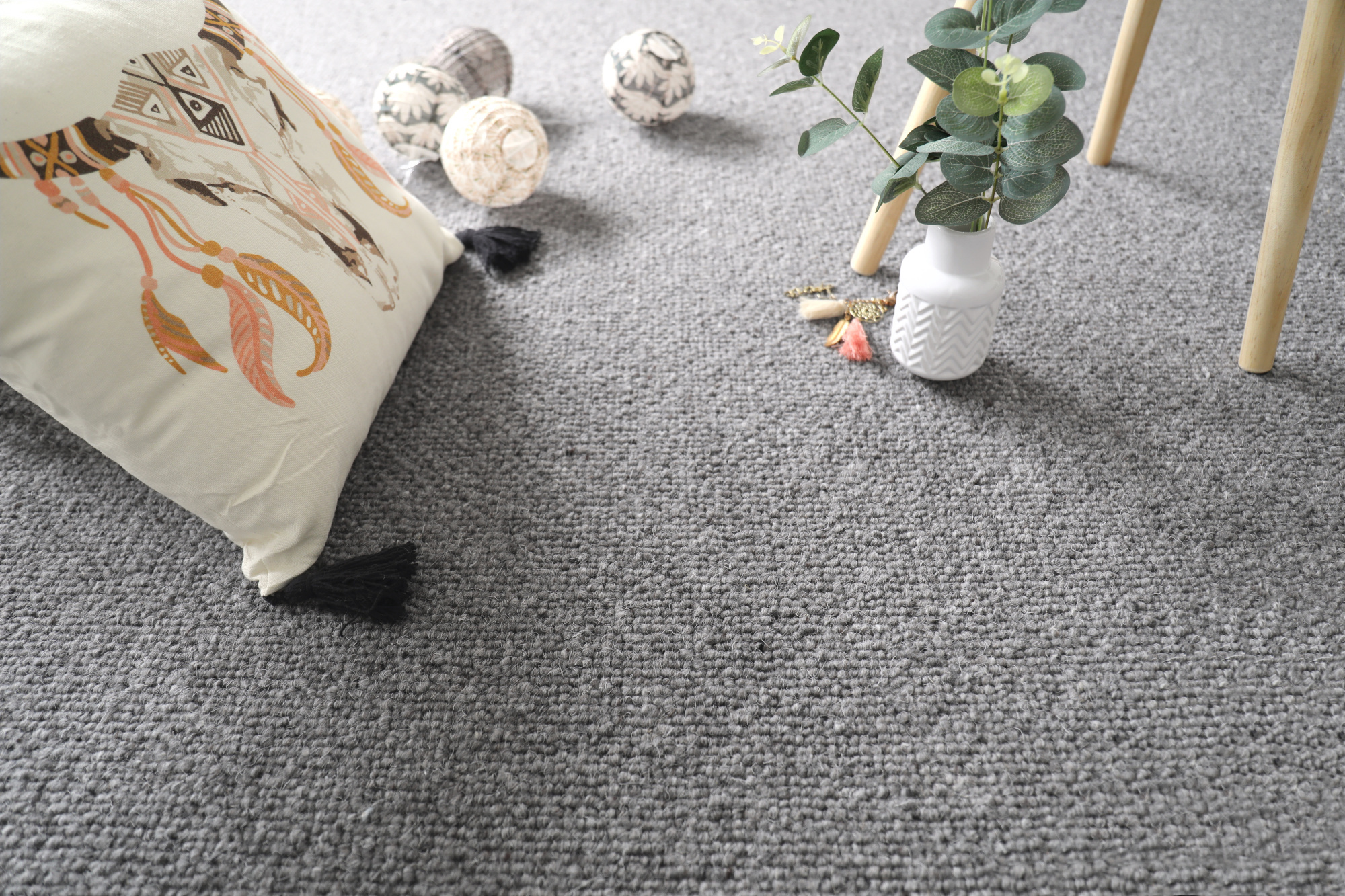 Moquette naturelle en laine Wooly - Gris feutré dans une chambre d'enfant avec coussin brodé, peluches et plante verte