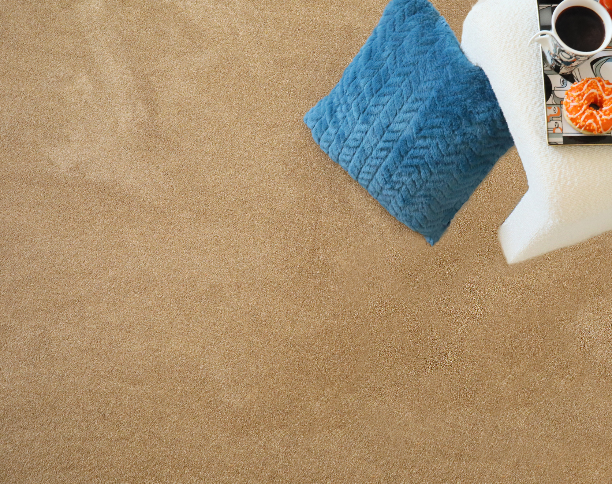 Moquette éco-conçue - Infini 11.5 - Camel présentée avec textiles bleus et petits objets décoratifs