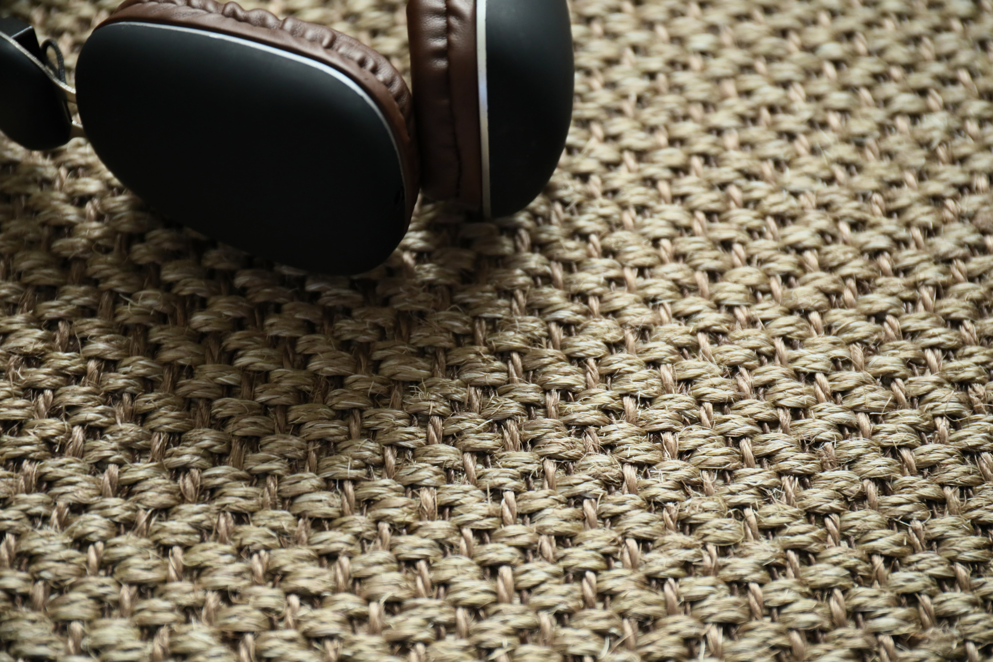 Sol Sisal - Grâce - Cordage avec casque audio posé sur un tissage en fibres naturelles aux nuances cordage