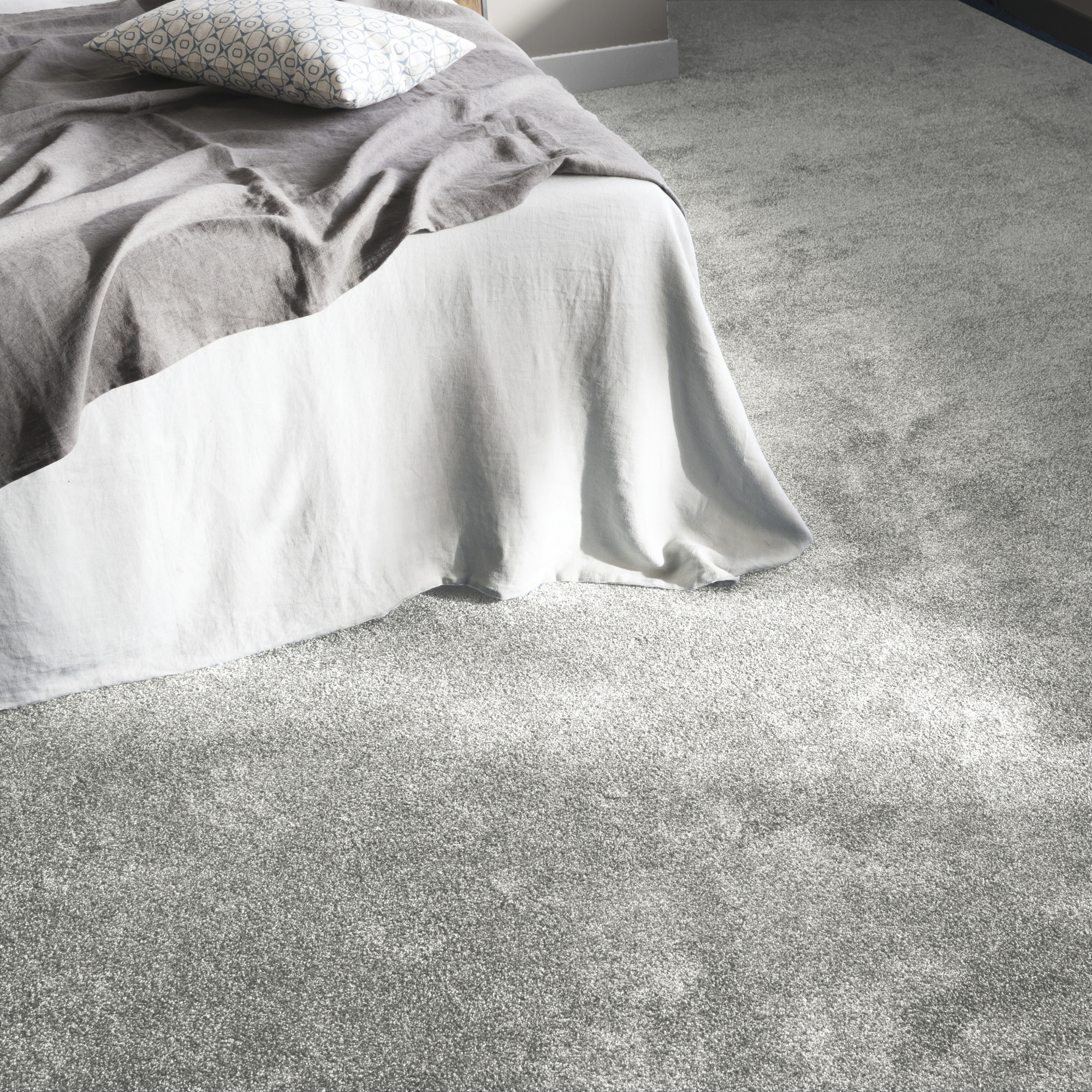Moquette douce Délicatesse - Gris urbain mettant en valeur un coin chambre élégant et confortable