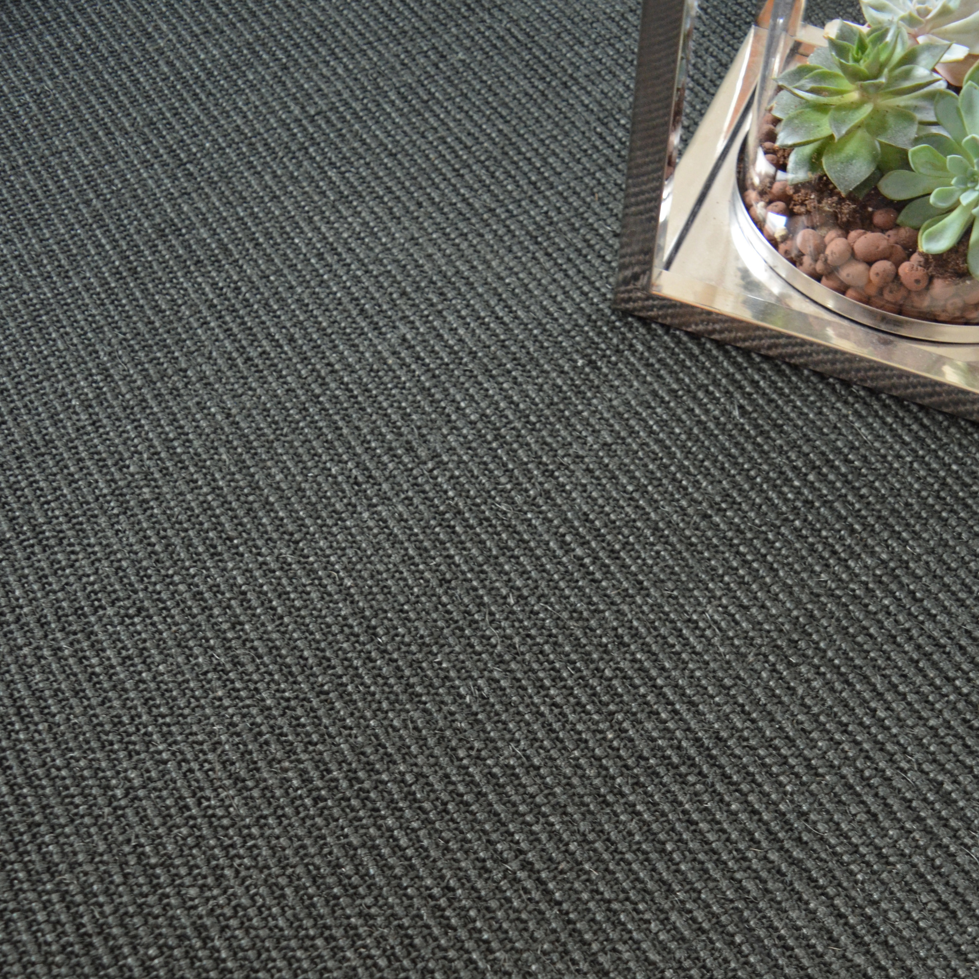 Sol Sisal - Minimal - Black Blue mettant en valeur son tissage près d'une décoration végétale