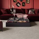 Ambiance intérieure riche où le tapis sur mesure Chroma Sense Soie beige adoucit le contraste des assises bordeaux