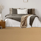 Sol Sisal - Grâce - Camel doré dans une chambre lumineuse avec linge de lit beige et décoration naturelle