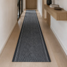 Tapis de passage Antidérapant au mètre - Anthracite habillant un long couloir aux murs clairs et au sol effet bois