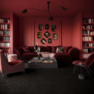 Vue large d’un salon élégant où la moquette Chroma Sense Noir carbone recouvre le sol, entouré de murs rouges