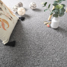 Moquette naturelle en laine Wooly - Gris feutré dans une chambre d'enfant avec coussin brodé, peluches et plante verte