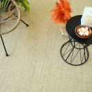 Sol Sisal - Crafted - Dune accompagné d'un fauteuil en fibres naturelles et d'une table ronde noire
