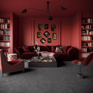 Ambiance immersive avec la moquette Chroma Sense Gris profond dans un salon spacieux aux tons bordeaux
