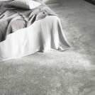 Moquette douce Délicatesse - Gris urbain mettant en valeur un coin chambre élégant et confortable