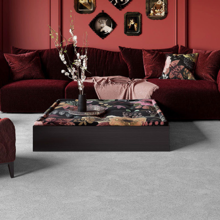 Moquette Chroma Sense Gris urbain dans un décor chaleureux, lumière douce et canapé texturé