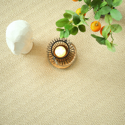 Sol Sisal Chevron - Jazz - Dune avec tissage chevron lumineux accompagné d'un vase blanc et d'une composition végétale