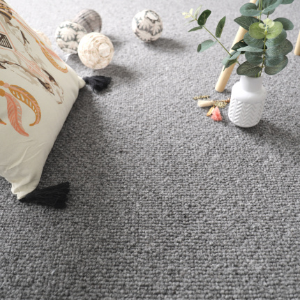 Moquette naturelle en laine Wooly - Gris feutré dans une chambre d'enfant avec coussin brodé, peluches et plante verte