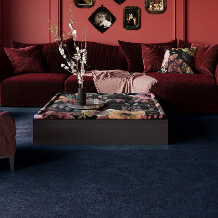 Moquette Chroma Sense Encre bleue dans une pièce aux tons rouges et bordeaux, atmosphère intimiste