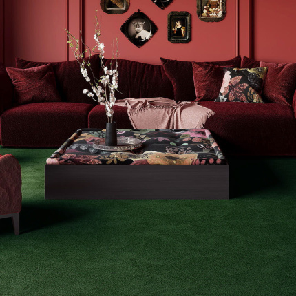 Moquette Chroma Sense vert foncé dans un salon chaleureux aux murs rouges, apportant douceur et densité au sol