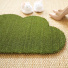 Tapis d'entrée déco Nuage - Fibre de Coco 17mm - Vert, silhouette originale accompagnée de chaussures dans une ambiance naturelle