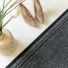 Tapis de passage Antidérapant au mètre - Anthracite associé à un sol clair, des escarpins et un vase en fibres naturelles