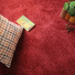 Moquette douce Délicatesse - Rouge gourmand avec coussin écossais, plante en pot et carnet posé sur le sol
