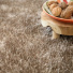 Moquette shaggy Glossy FusionBac Muscade, longues fibres moelleuses autour d'un panier décoratif en bois