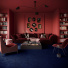 Salon à l’atmosphère feutrée où la moquette Chroma Sense Encre bleue adoucit le contraste des murs rouges
