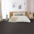 Sol Sisal - Minimal - Black Blue dans une chambre avec lit beige et plantes vertes