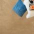 Moquette éco-conçue - Infini 11.5 - Camel présentée avec textiles bleus et petits objets décoratifs